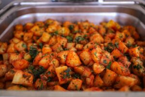 Delicious roasted potatoes with Moroccan spices and herbs at a buffet, perfect for iftar.
